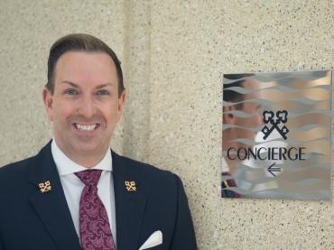 Robert Marks Chef Concierge Of Omni Hotel San Diego Standing Next to Clefs D'Or International Sign