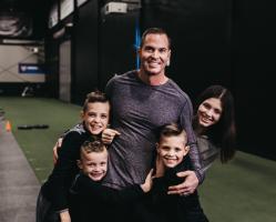 Jason Batt Smiling And Hugging His Children