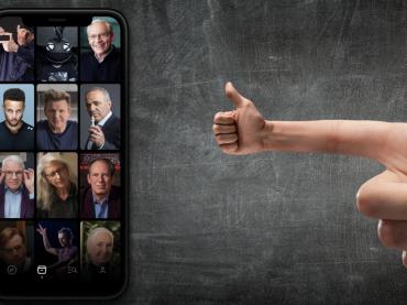 Hand Making Thumbs Ups To Mobile Phone With Famous People Photos On Phone Screen