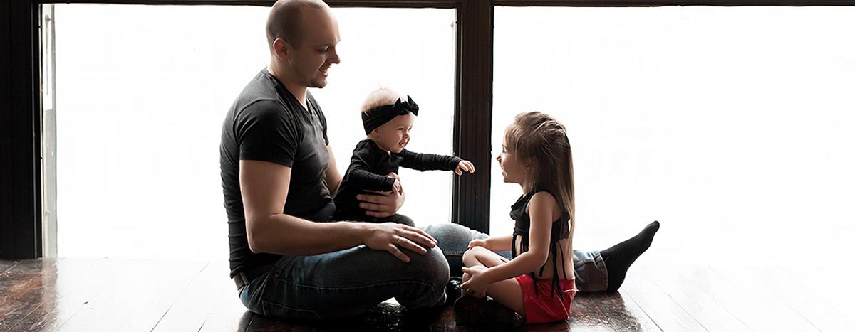 a-loving-father-with-his-daughters-sitting-by-big-window