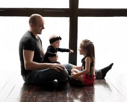 a-loving-father-with-his-daughters-sitting-by-big-window