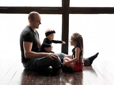 a-loving-father-with-his-daughters-sitting-by-big-window