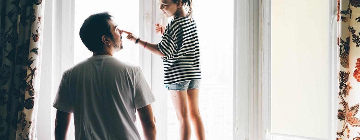 happy-father-and-daughter-playing-by-window