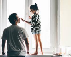 happy-father-and-daughter-playing-by-window