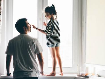 happy-father-and-daughter-playing-by-window