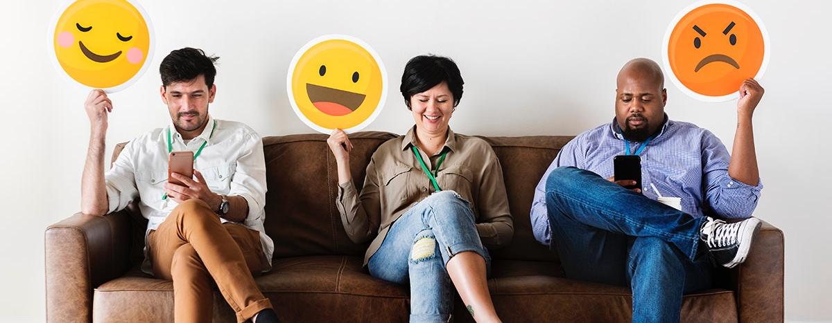 diverse-adult-people-sitting-and-holding-emojis-signs