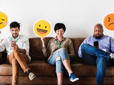 diverse-adult-people-sitting-and-holding-emojis-signs