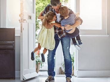 father-hugging-kids-in-house-doorway