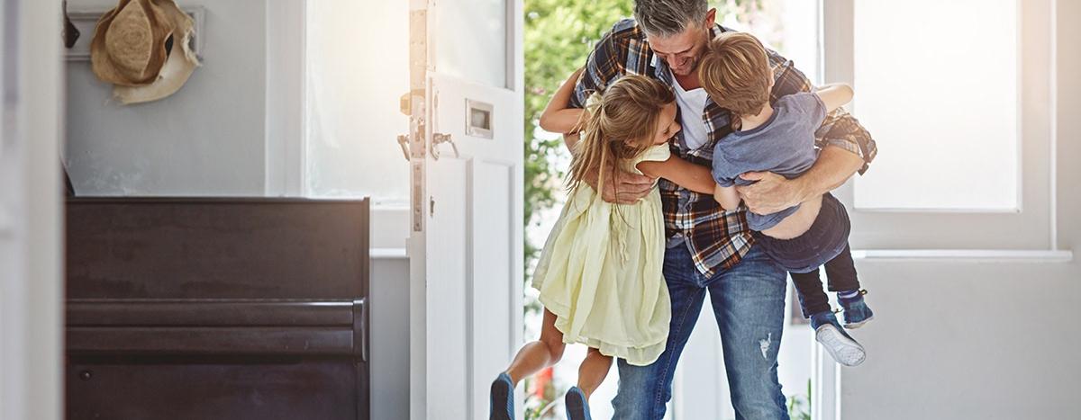 father-hugging-kids-in-house-doorway