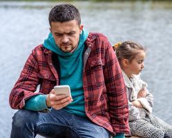 dad-with-a-phone-in-his-hands-does-not-pay-attention