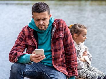 dad-with-a-phone-in-his-hands-does-not-pay-attention