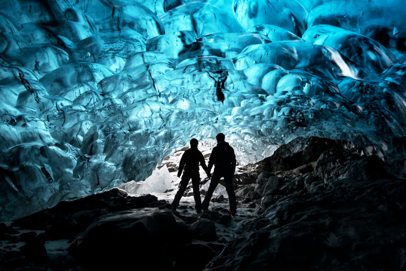 Silhouette Of Couple Holding Hands in Ice Cave In Iceland