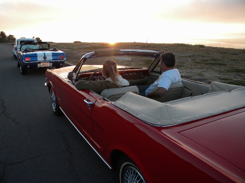 Red And Blue Ford Mustang Cruising Along The California Coast Highway