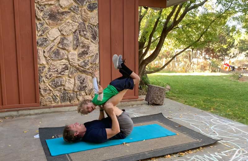 Sorren Harrison Of Fit Daddy 365 Doing 5 Lying Leg Lifts With Son On Laying On His Legs