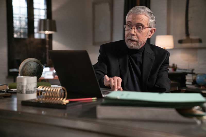 Economist Paul Krugman Sitting At Desk Working On Computer