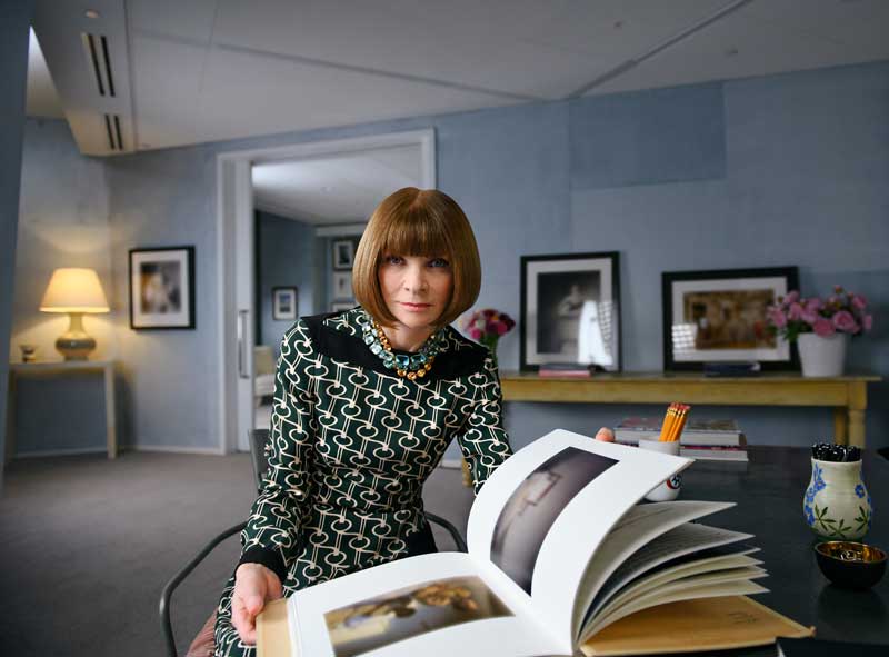 Fashion Guru Anna Wintour Holding Open Book While Seated In Her Office