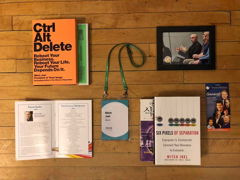 Mitch Joel Collage Of Items On Table Ctrl Alt Delete Book And Six Pixels Of Separation Book