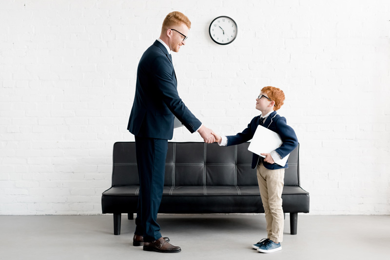 Business Man Shaking Hand With His Son Dressed Like Him