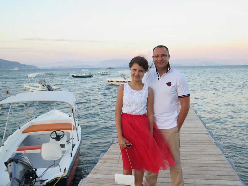 Vasyl Myroshnychenko With Daughter Standing On Dock By Water In Western United States